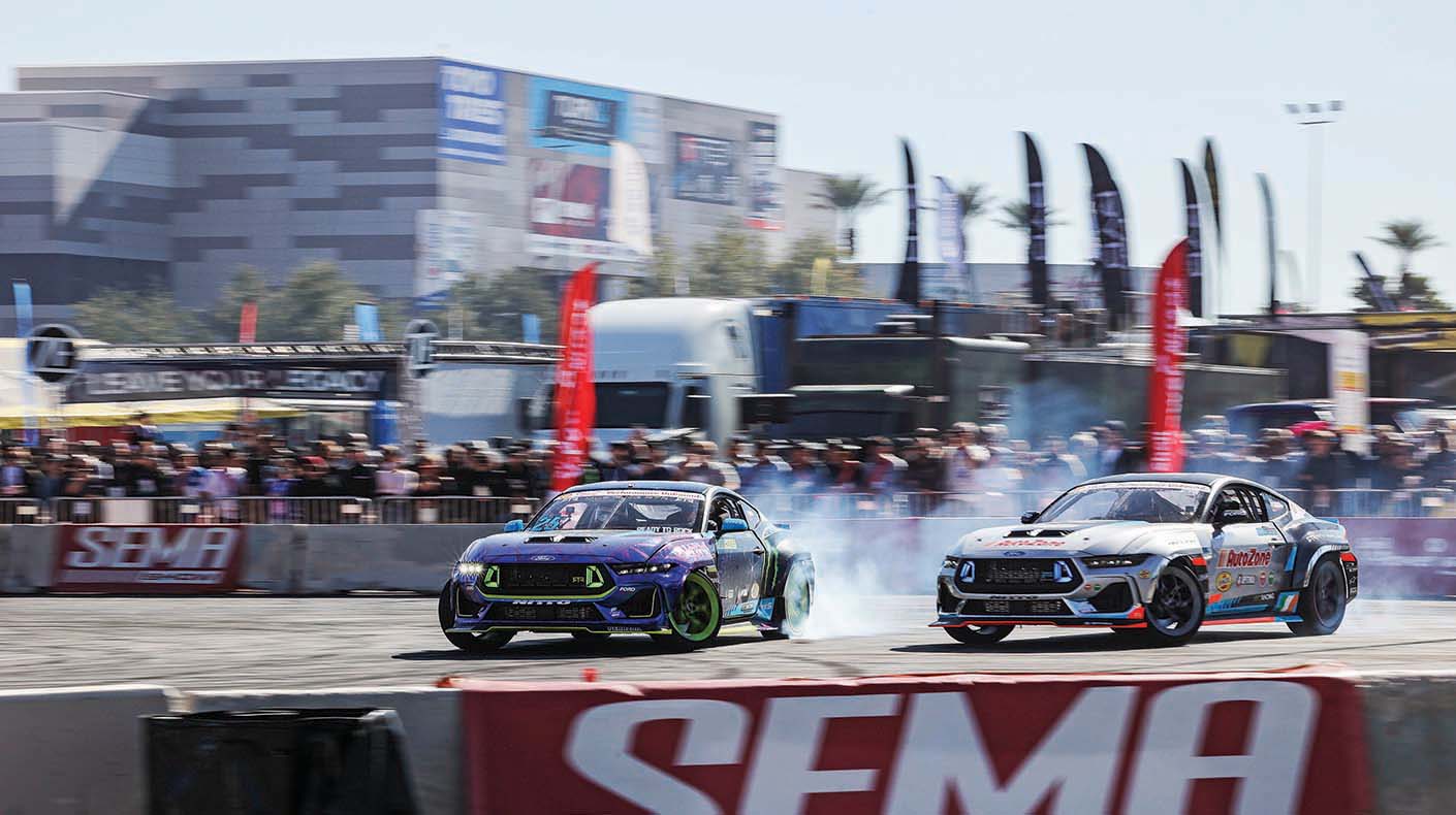 Two cars drifting together in a closed course
