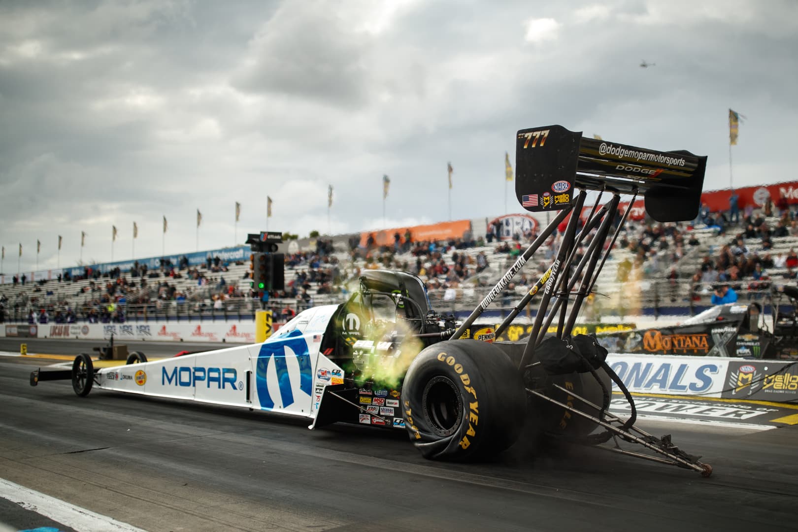 Top fuel dragster launching on track during race event