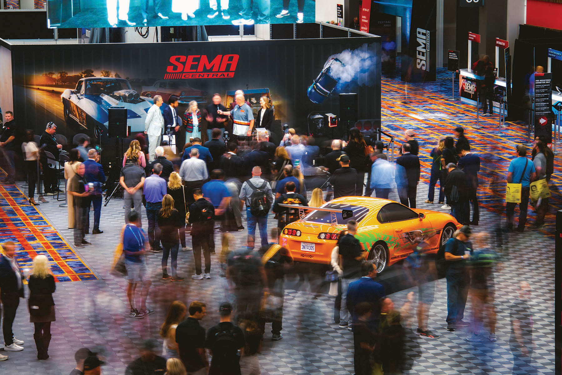Top down view of the SEMA Central with people gathered around a stage to see a presentation