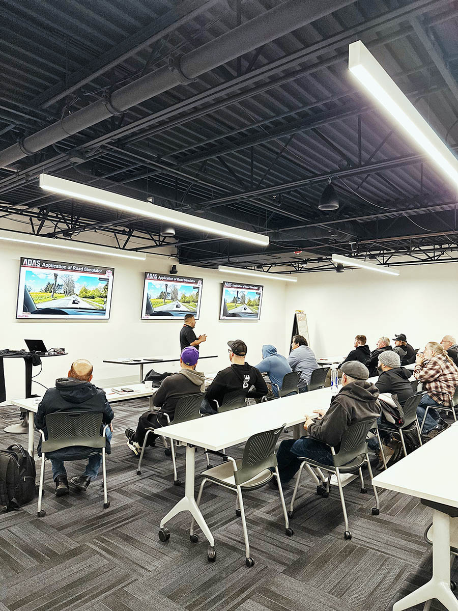 Students seating at tables listening to a presenter.