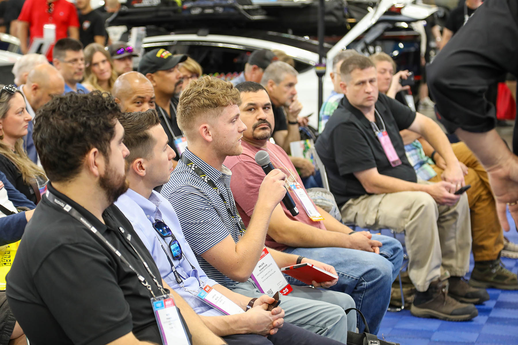 Attendees look on as one of them asks a question at a session