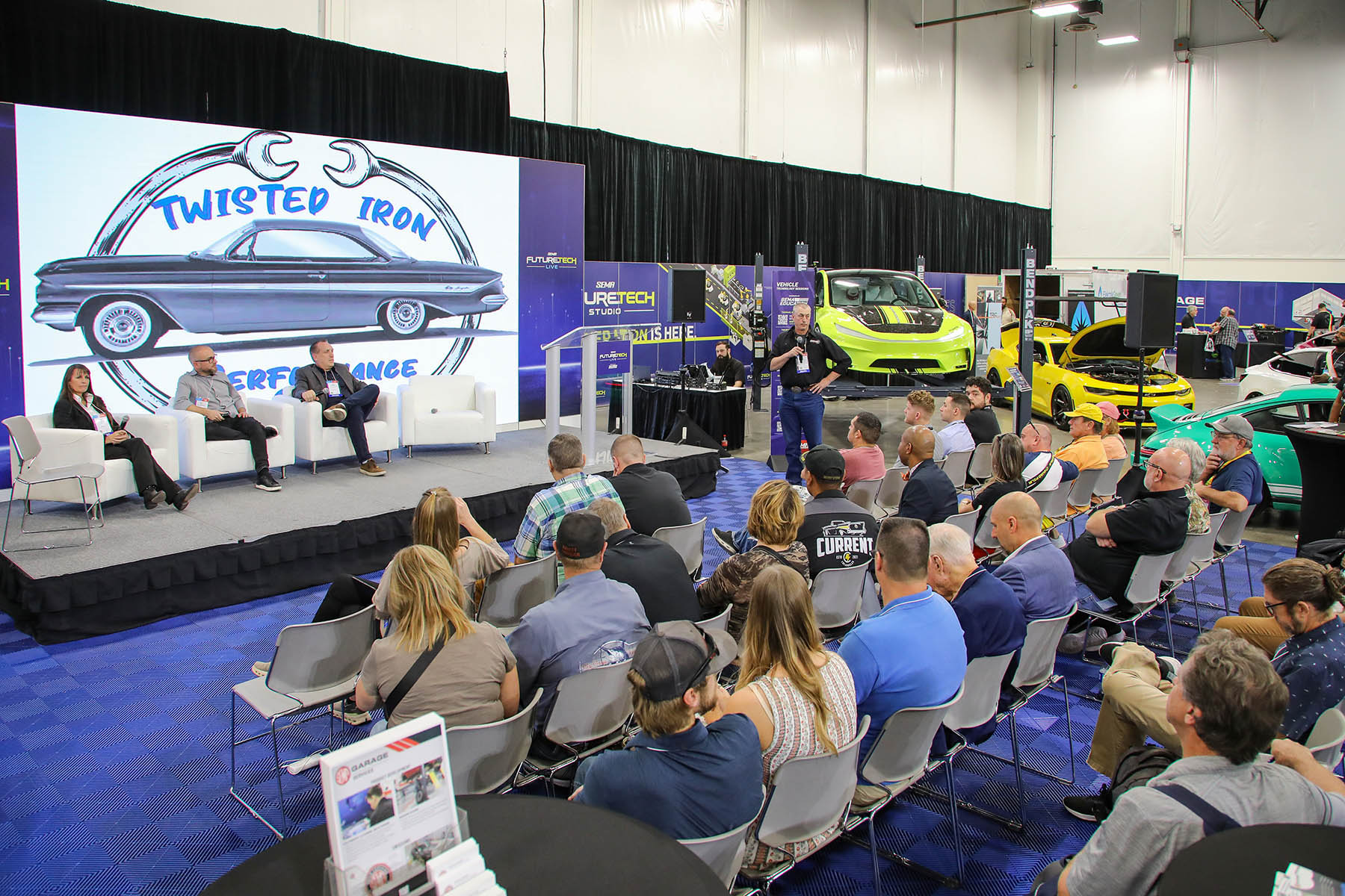 Attendees listen to a panel during a session at the Future Tech booth